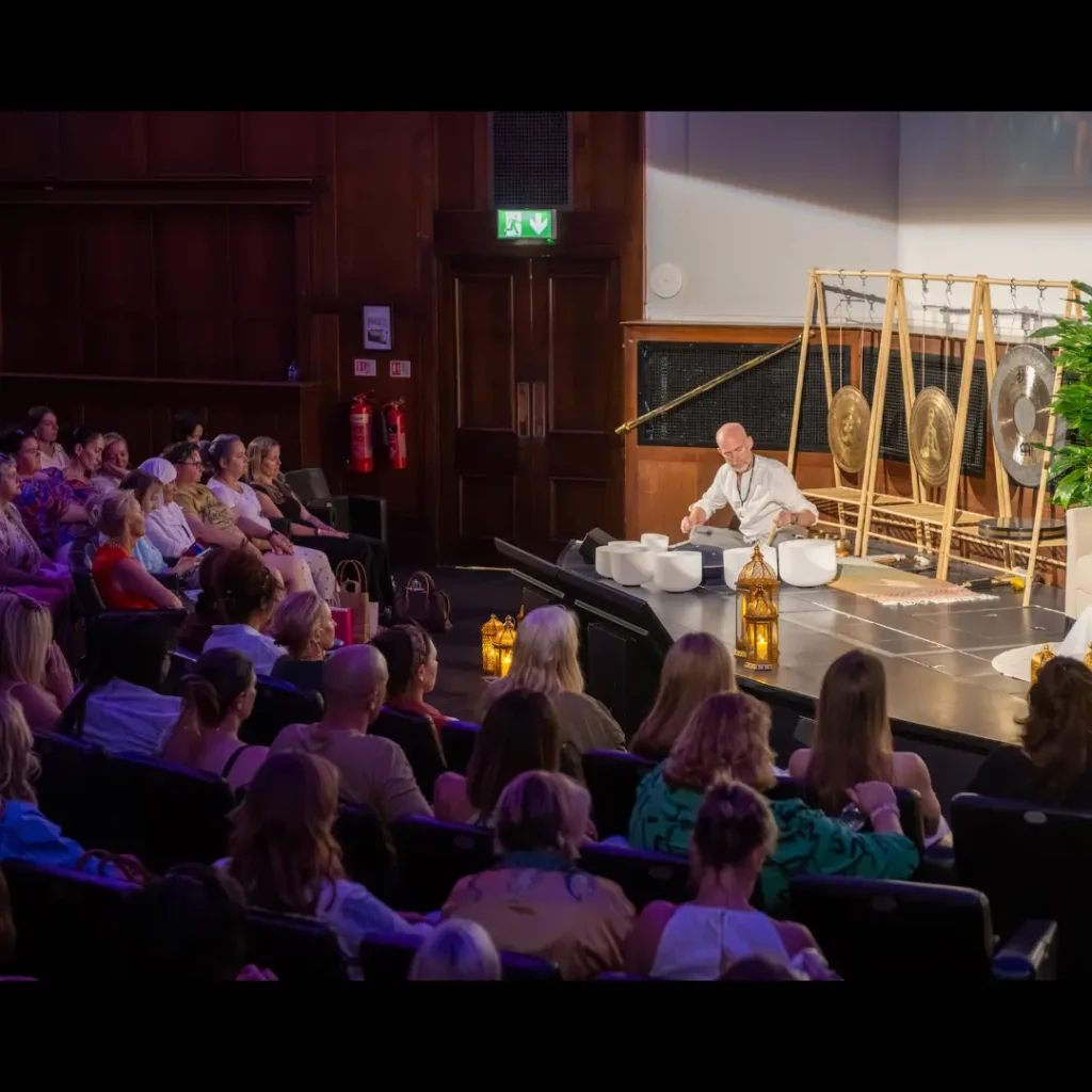 About Neil Perry-Timson playing singing bowls on stage during Karen Ruimy’s London event.